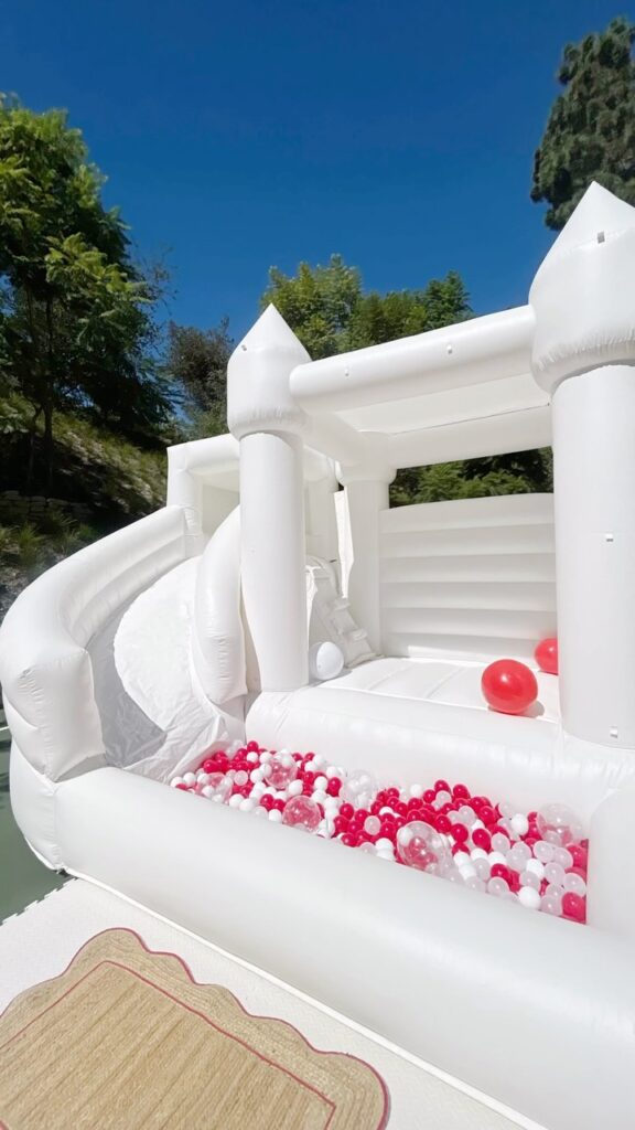 White castle bounce house with slide and red and white ball pit