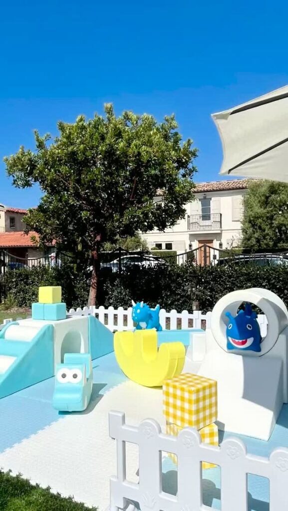 Light blue soft play with dinosaur and car pieces outdoors