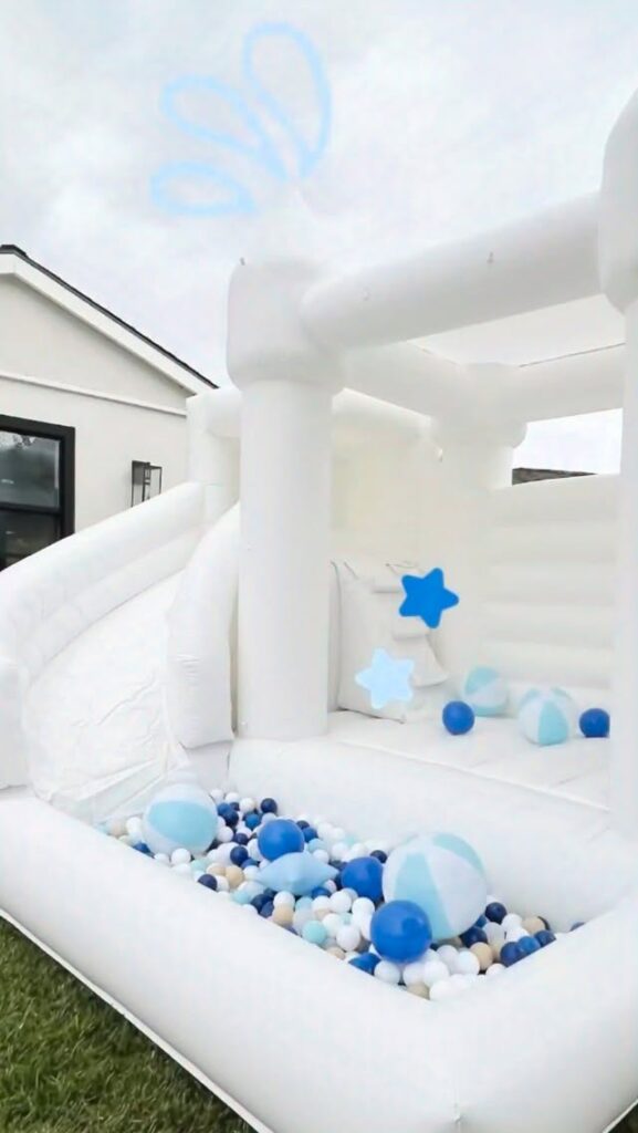 White bounce house with blue and white ball pit
