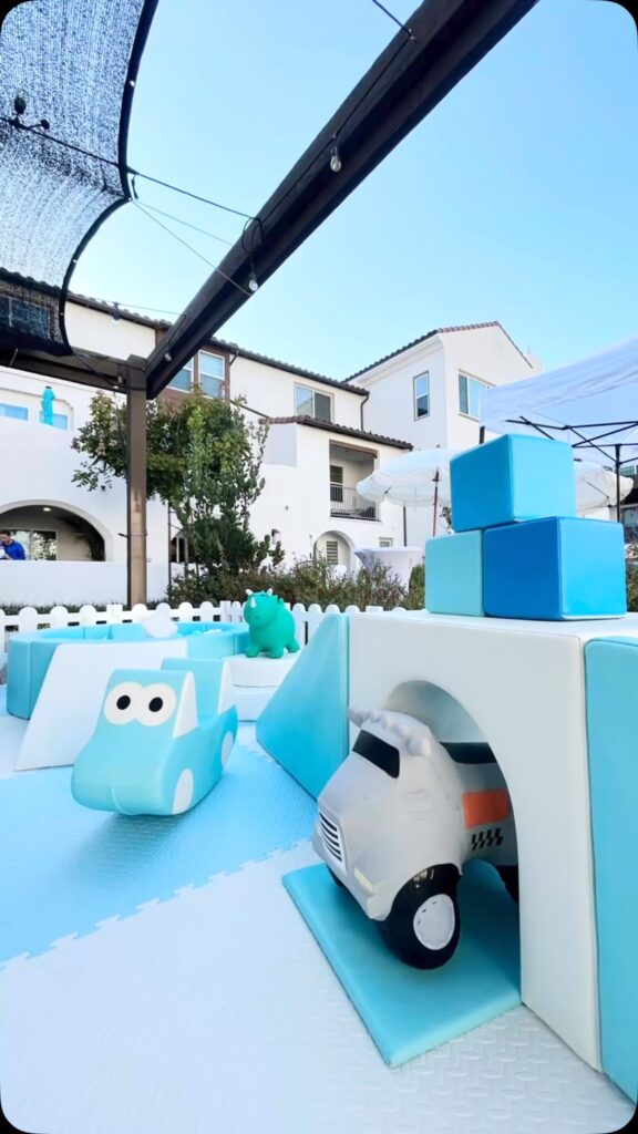 Light blue soft play with car pieces on a patio