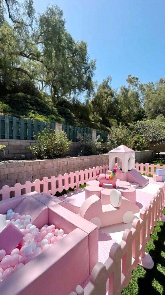 Pink soft play and pink ball pit in a hillside backyard