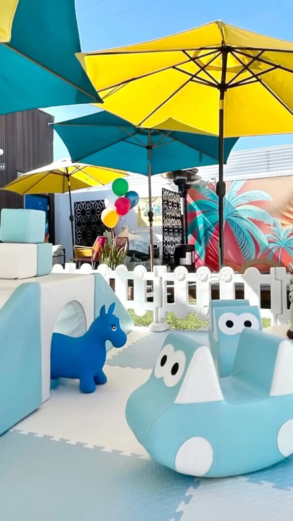 Light blue soft play under yellow and teal umbrellas