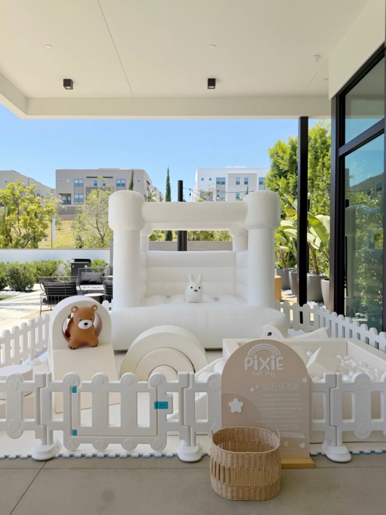 White bounce house and soft play on a covered patio